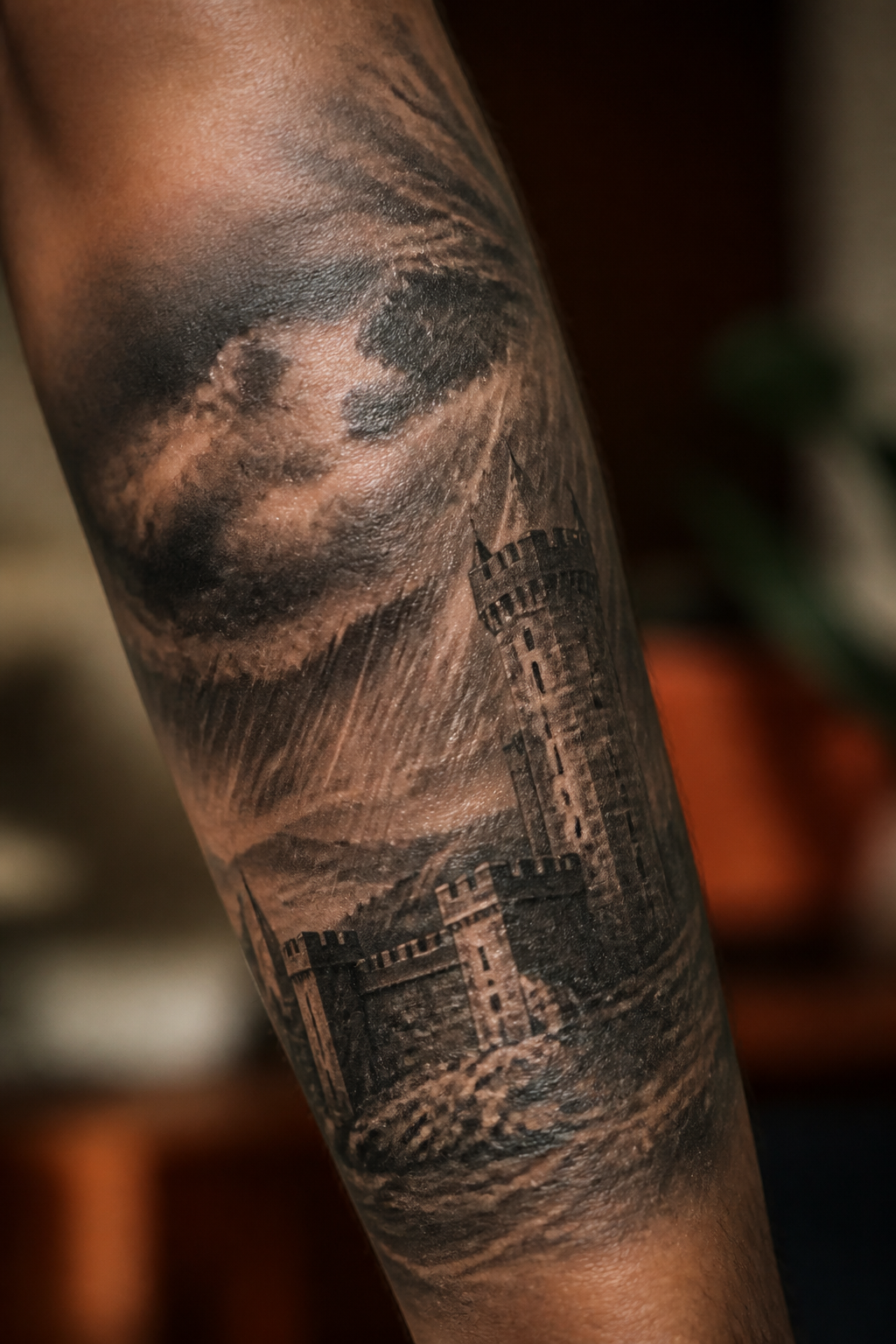 Storm fortress black and gray tattoo wrapping a forearm
