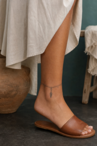 Ornamental anklet tattoo with delicate leaf charm