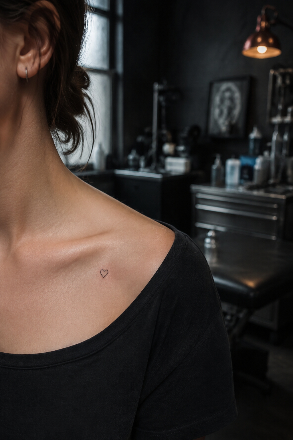 A tiny clean heart outline near an adult woman's collarbone.