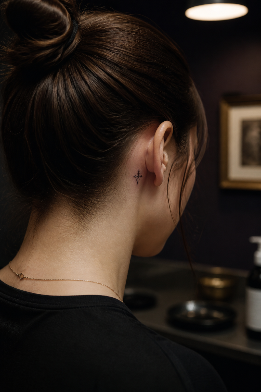 Tiny ornamental cross tattoo behind the ear